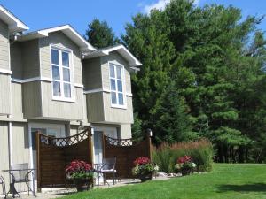 una casa con una valla y sillas en el patio en Auberge Aux Deux Pères en Magog-Orford