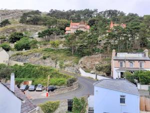 a winding road with cars parked on a hill at The Penthouse in Llandudno