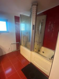 y baño con ducha y bañera con azulejos rojos. en Мезонет “Djanina” en Sandanski