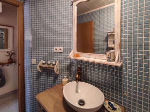 Baño de azulejos azules con lavabo y espejo en Aiguabarreig, en Ripoll