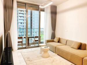 a living room with a couch and a large window at Morden 2brs apartment at Empire City in Ho Chi Minh City