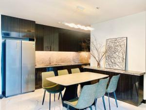 a kitchen with a table and chairs and a refrigerator at Morden 2brs apartment at Empire City in Ho Chi Minh City