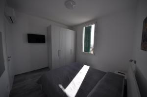 ein Schlafzimmer mit einem Bett und einem Fenster in der Unterkunft Agriturismo Ca du Bega in Arma di Taggia + 18 Fotos