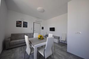 ein Esszimmer mit Tisch und Stühlen und einer Couch in der Unterkunft Agriturismo Ca du Bega in Arma di Taggia