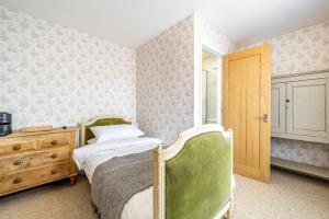 sypialnia z 2 łóżkami i drewnianą komodą w obiekcie The Whichcote Arms 
