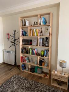 una estantería llena de libros en una habitación en Deluxe Studio com terraço e varanda privada - 'Casinha da Amoreira' Guesthouse en Coímbra