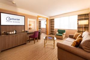 a living room with a couch and a flat screen tv at Copthorne Hotel Slough Windsor in Slough