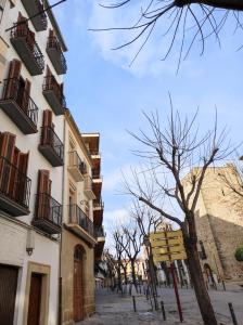 un edificio con balconi e un albero su una strada di Sol Rastro a Úbeda