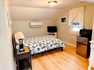 a small bedroom with a bed and a television at Sandy Neck Motel in Sandwich