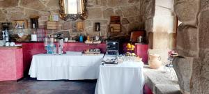 a kitchen with two white tables in a room at Casa Rural Pazo San Damian in Amoeiro