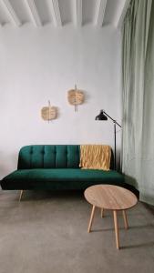 a green couch in a living room with a table at El 34 in Lorca