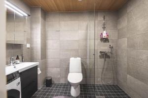 a bathroom with a shower and a toilet and a sink at Ydinkeskustassa saunallinen loft huoneisto in Kuopio