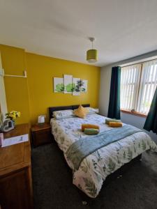 a bedroom with a large bed with yellow walls at Deeside Holiday Cottages in Dinnet