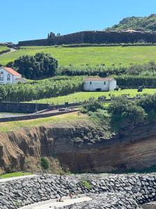 a view of a field with a building on a hill at Casa da Luz in Angra do Heroísmo