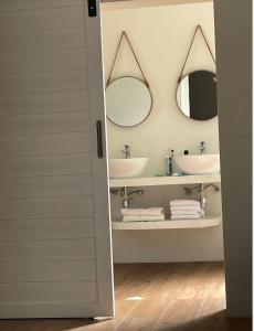 a bathroom with two sinks and two mirrors at Leopards Hill, Lusaka family home in beautiful nature in Mwambula