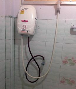 a hair dryer on the wall of a bathroom at Chuanchom Resort in Phatthalung