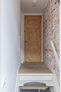 a staircase with a wooden door and a brick wall at Cozy Typical Dutch Apartments in Groningen