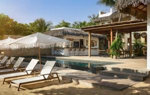 uma villa com uma piscina e espreguiçadeiras em Villa Praia - La Villa Group em Jericoacoara