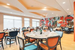 une salle à manger avec des tables et des chaises ainsi qu'une fresque murale. dans l'établissement Domitys La Cristal'In, à Nancy