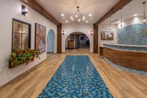 eine Lobby mit blauem Fliesenboden und einer Bar in der Unterkunft Grand Williston Hotel and Conference Center in Williston