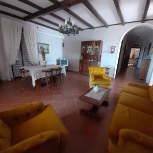 sala de estar con muebles de color amarillo y mesa en B&B Villa Rosalia, en Barrafranca