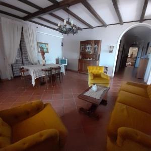 a living room with yellow furniture and a table at B&B Villa Rosalia in Barrafranca +47 photos