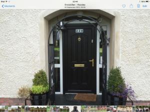 a black front door of a house with two plants at Fermanagh lakeside Self Catering in Corranny