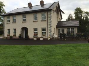 una gran casa blanca con una puerta y un patio en Fermanagh lakeside Self Catering, en Corranny