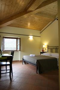 a bedroom with a bed and a desk and a window at Locanda Il Monastero in Ortonovo