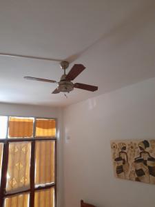 a ceiling fan in a room with a window at La Cloty in Paraná