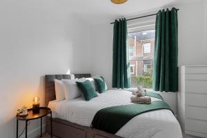 a bedroom with a bed with green curtains and a window at Church View II by Staytor Accommodation in Exeter