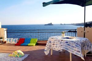 een tafel en stoelen op een balkon met uitzicht op de oceaan bij Al Capo in Acireale