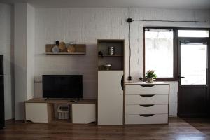 ein Wohnzimmer mit einem TV und einer Kommode mit einem TV in der Unterkunft Studio Panagyurishte in Panagjurischte