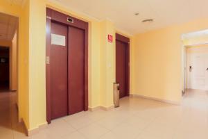 a hallway with two brown doors and yellow walls at Hotel Tuto in Torrevieja