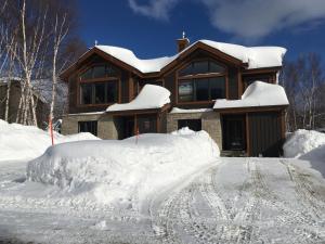 a house with a pile of snow in front of it at Hébergement JFL in Saint-Férréol-les-Neiges
