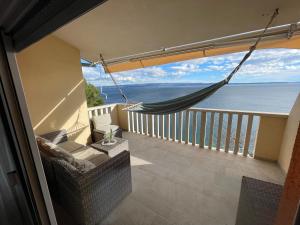 a balcony with a hammock and a view of the ocean at Super Horizont beach house-FREE PARKING in Split