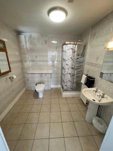 a bathroom with a toilet and a sink and a shower at Lost Guest House Aberdeen in Aberdeen