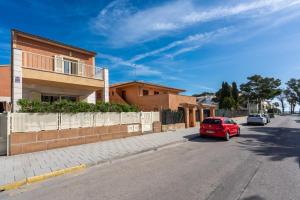 a red car parked on the side of a street at M4R Casa Iuca in Alcudia