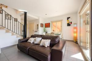 a living room with a brown leather couch at M4R Casa Iuca in Alcudia