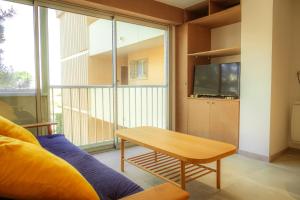 een woonkamer met een tafel en een groot raam bij Magnifique appartement de type loft en front de mer avec vue, parking et WiFi in Argelès-sur-Mer