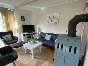 a living room with a couch and a stove at Nordseejuwel in Friedrichskoog-Spitz