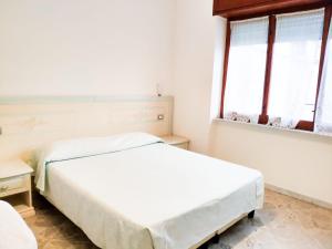 two beds in a white room with two windows at Atrani - Le Case Della Costa in Maiori