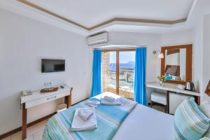 a bedroom with a bed and a desk and a sink at Hotel Sonne - Adults Only in Kaş