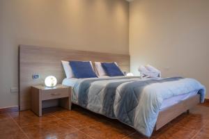 a bedroom with a bed with blue sheets and a night stand at B&B a due passi dal mare in Caulonia Marina