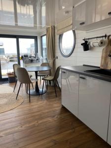 een keuken en eetkamer met een tafel en stoelen bij SeaYou House boat in Offingawier
