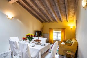 a dining room with a white table and chairs at Flowers Apartments in Desenzano del Garda