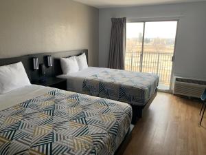 a hotel room with two beds and a window at Studio 6-Lincoln, NE - Airport in Lincoln
