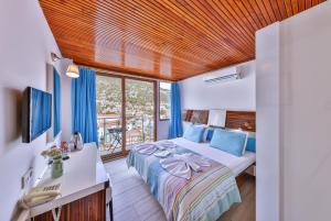 a bedroom with a bed and a desk and a window at Hotel Sonne - Adults Only in Kaş