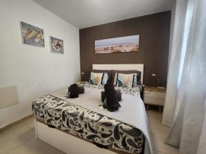 een slaapkamer met een bed met een witte sprei bij Bungalow Silvia in Caleta De Fuste