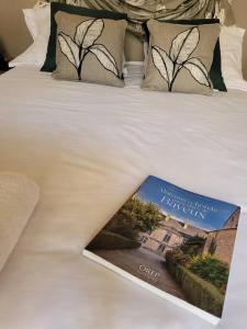 un livre sur un lit avec un livre sur le lit dans l'établissement LA MAITRISE, à Bayeux